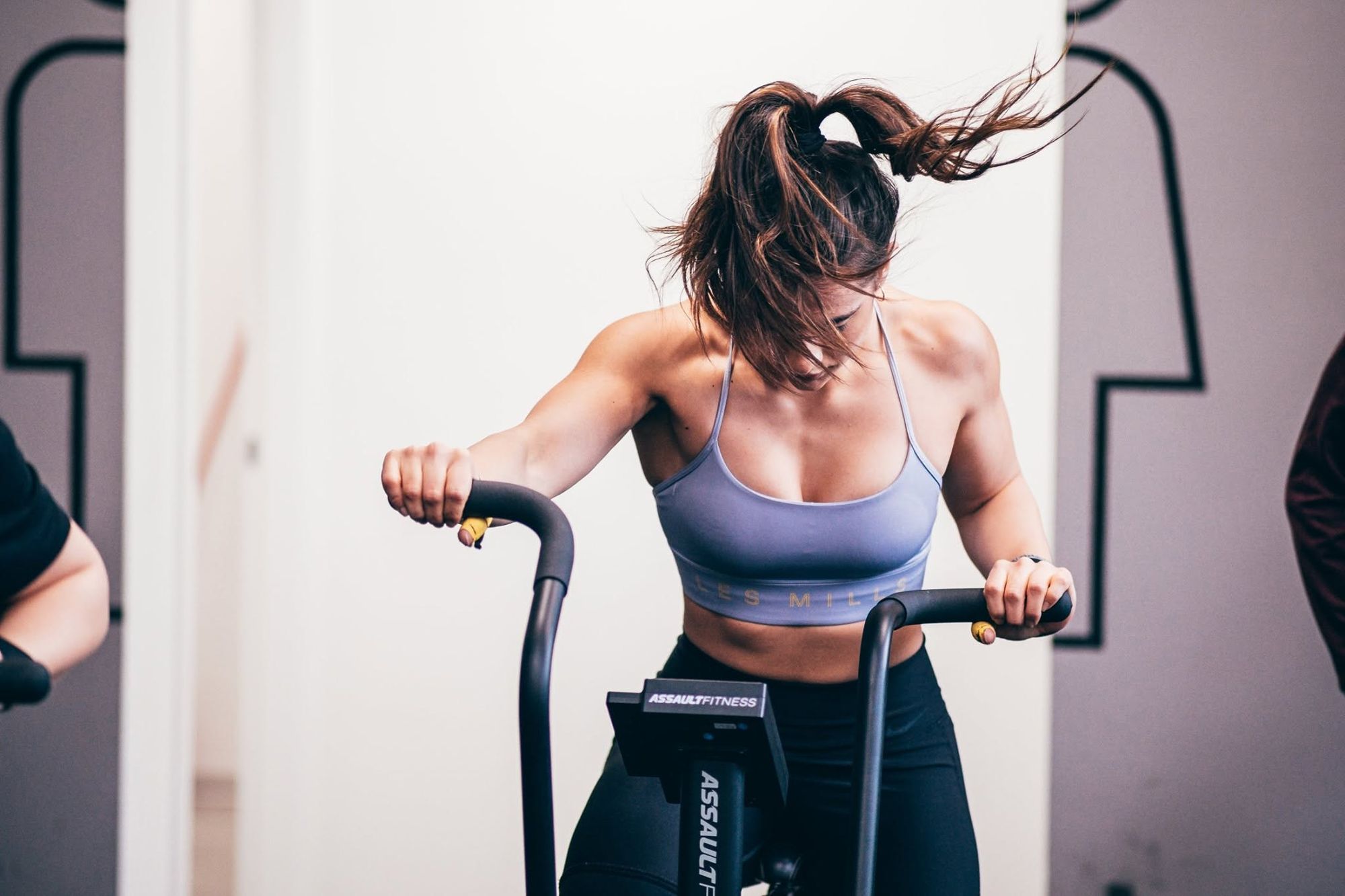 Un’atleta sull’air bike, capelli al vento